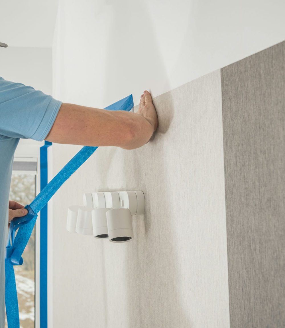 Caucasian Men in His 40s Replacing Old Vinyl Wallpaper Inside His Apartment. Home Improvement Theme.